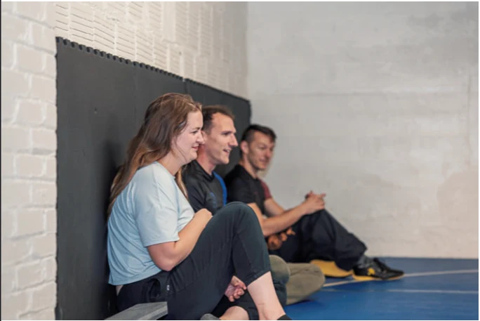 Training partners sitting against the wall, talking between rounds